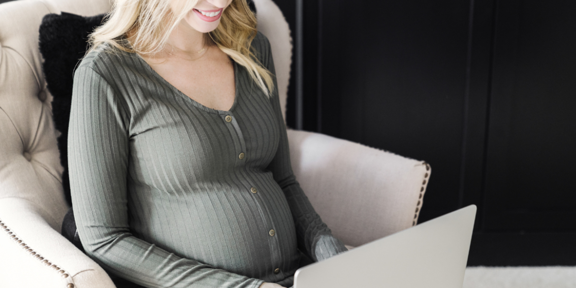 pregnant lady blogging  on laptop at home 