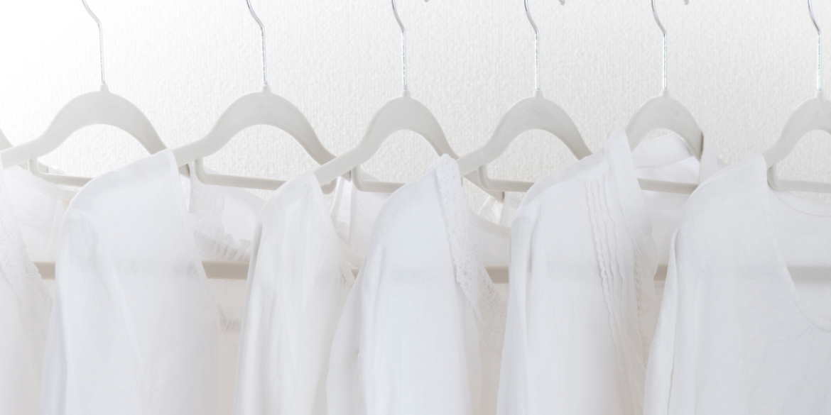 white clothes hanging on hangers