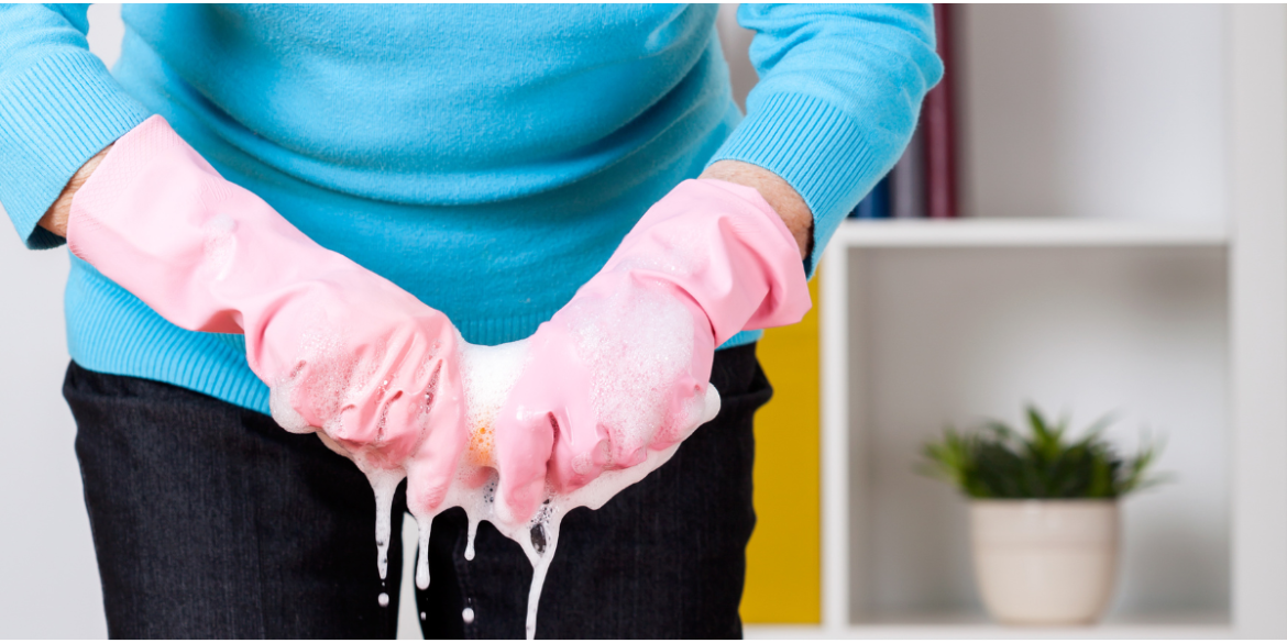 lady wringing out a cloth wearing pink rubber gloves