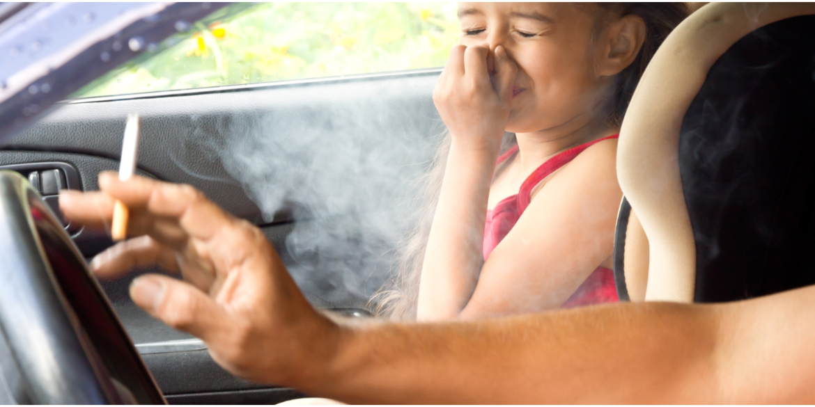 little girl distressed by her dad smoking in car