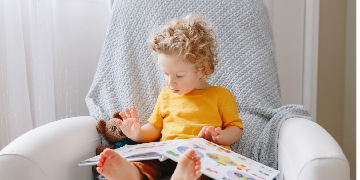 toddler reading in a cozy chair