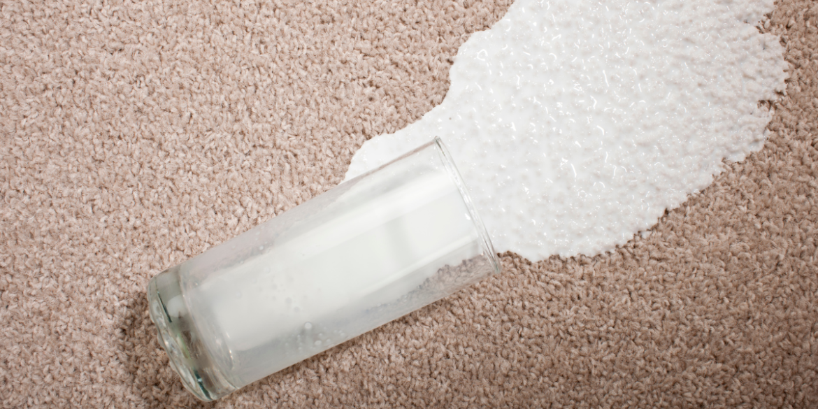 glass of milk spilled on a carpet